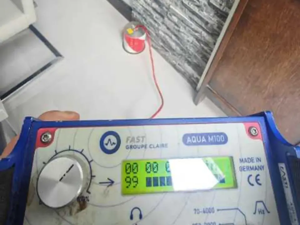 Acoustic listening unit displaying readings on tiled floor during leak detection